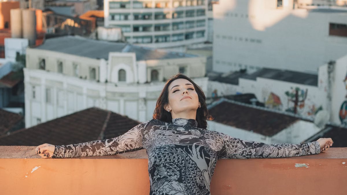 Woman relaxing on a rooftop in the city, enjoying a sunny day. Urban tranquility amidst skyscrapers.